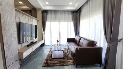 Luxurious living room with modern decor, large windows, and elegant furniture.