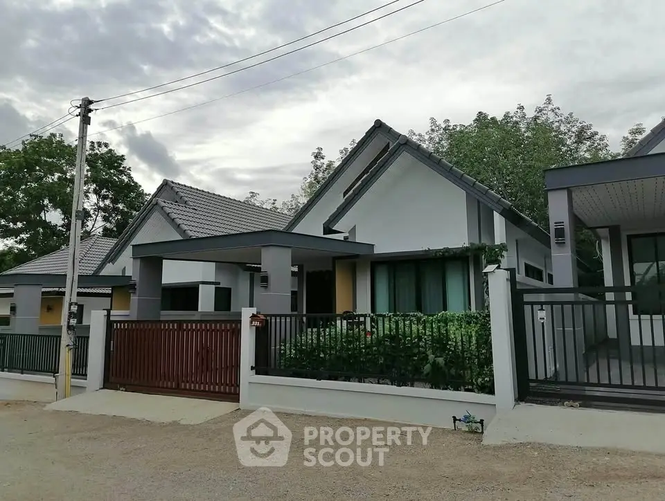 Modern single-story house with sleek design and spacious driveway in a serene neighborhood.