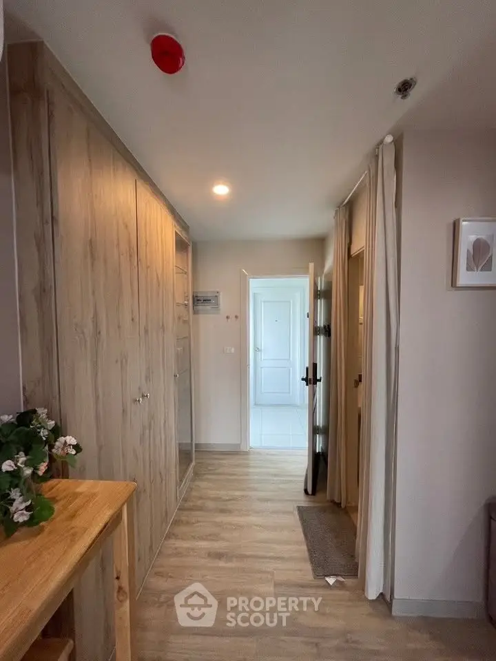 Charming hallway with wooden flooring and ample storage in modern apartment