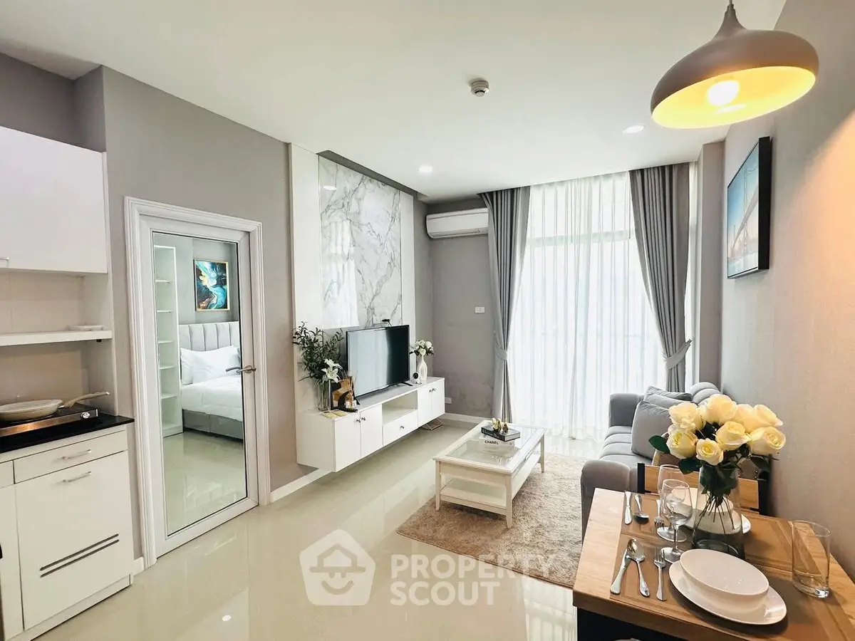 Modern living room with elegant decor and natural light, featuring a cozy sofa and stylish dining area.