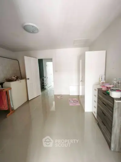 Spacious bedroom with modern furniture and glossy tiled flooring, perfect for a cozy living experience.