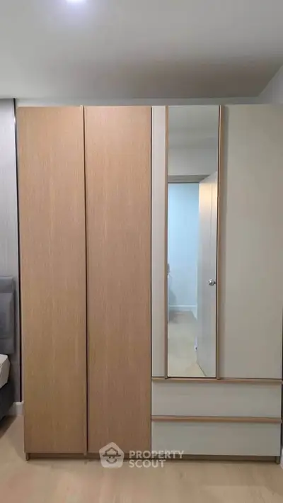 Modern bedroom with sleek wardrobe and neutral tones, perfect for stylish storage solutions.