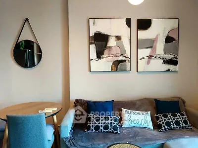 Stylish living room with modern art and cozy seating in a contemporary apartment.