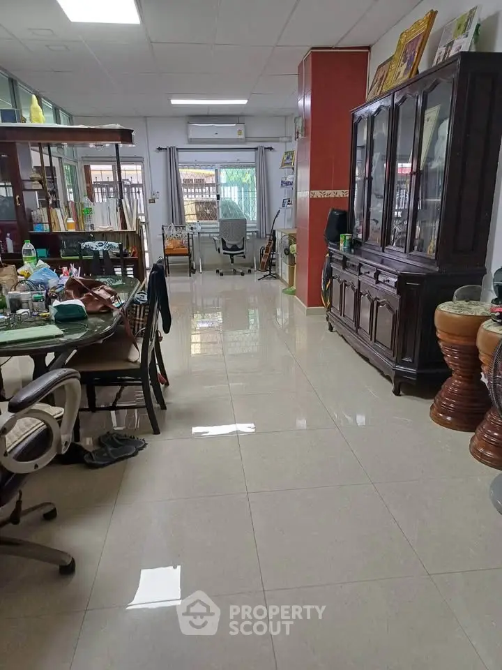 Spacious living room with elegant furniture and glossy tiled flooring, perfect for family gatherings.