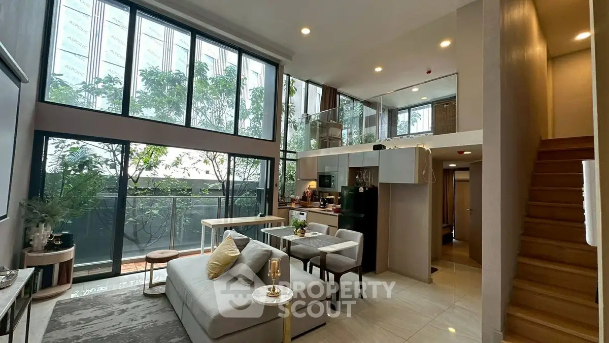 Luxurious modern living room with high ceilings and large windows, featuring stylish furniture and open kitchen layout.