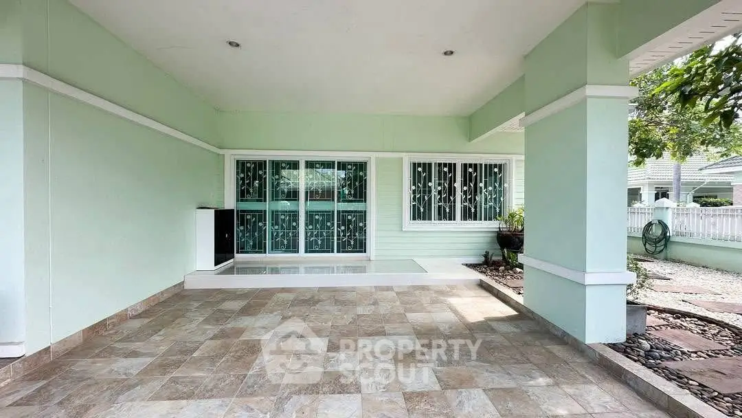 Spacious covered patio with tiled flooring and garden view