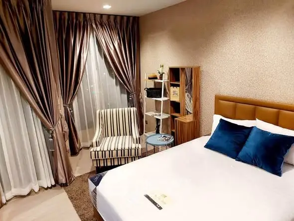 Luxurious bedroom with elegant decor and plush bedding in modern apartment.