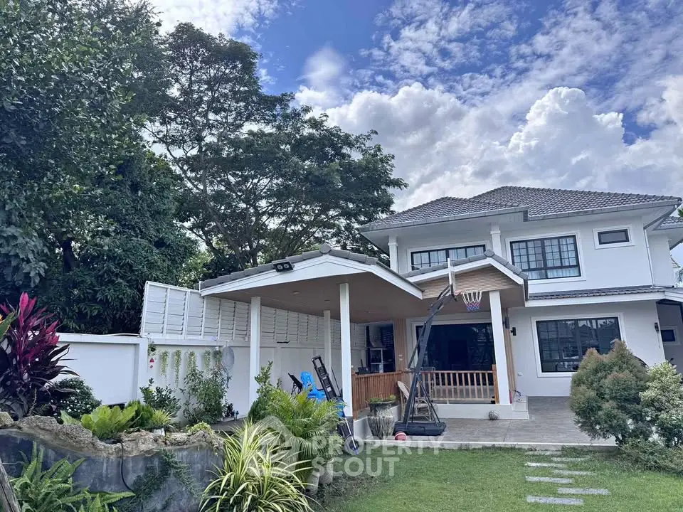 Stunning two-story house with lush garden and basketball hoop, perfect for family living.