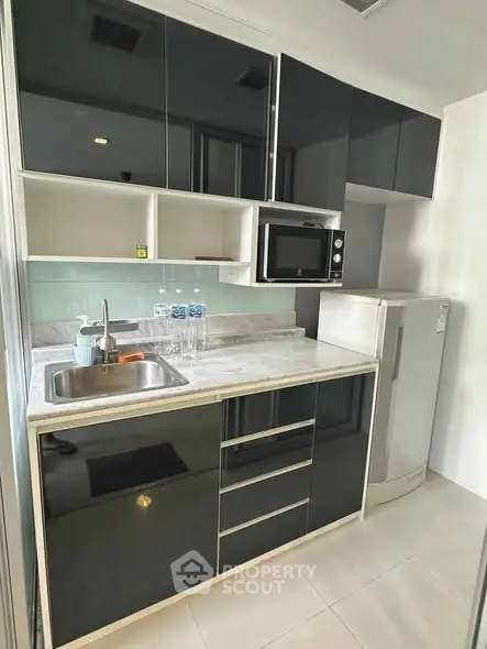 Modern kitchen with sleek black cabinets and appliances