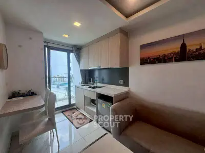 Modern kitchen with open layout and city view, featuring sleek cabinetry and cozy dining area.