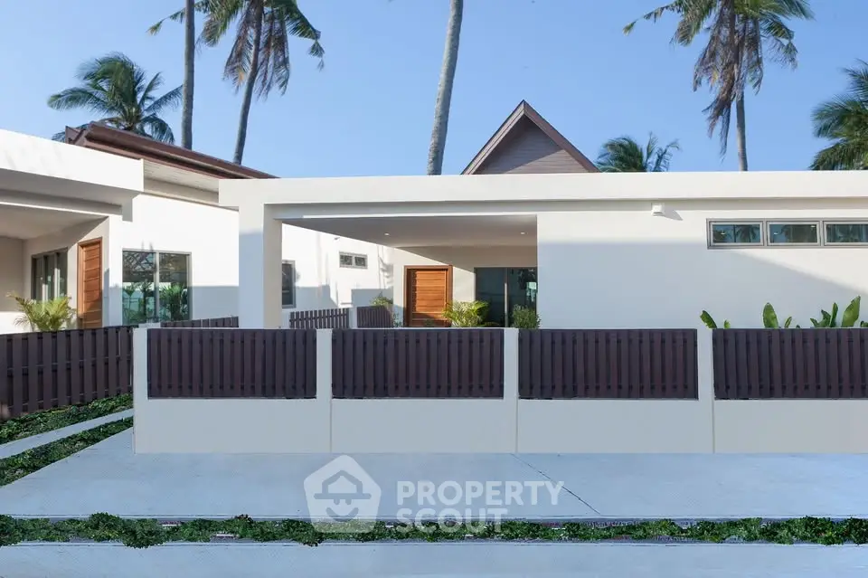 Modern tropical villa with sleek design and palm trees, offering serene living in paradise.