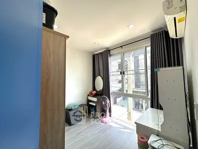 Bright bedroom with large window, modern furnishings, and air conditioning unit.