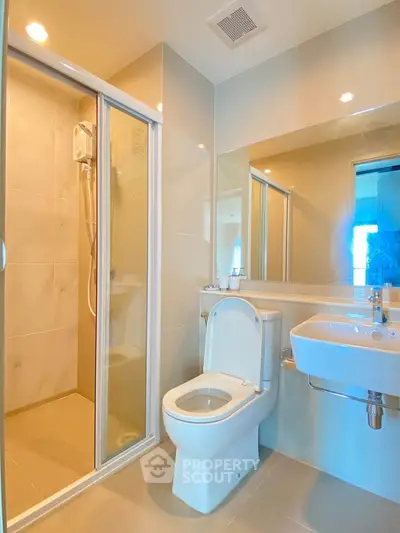 Modern bathroom with glass shower and sleek fixtures in a contemporary apartment.