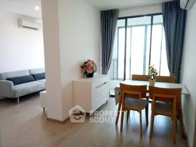 Modern open-plan living and dining area with natural light and stylish furniture.