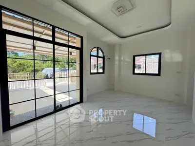 Spacious modern living room with large windows and elegant flooring