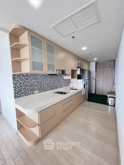 Modern kitchen with sleek cabinetry and integrated appliances in stylish apartment.