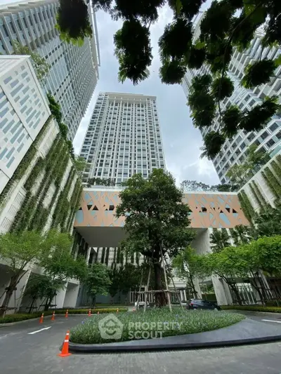 Stunning modern high-rise building with lush greenery and unique architectural design.