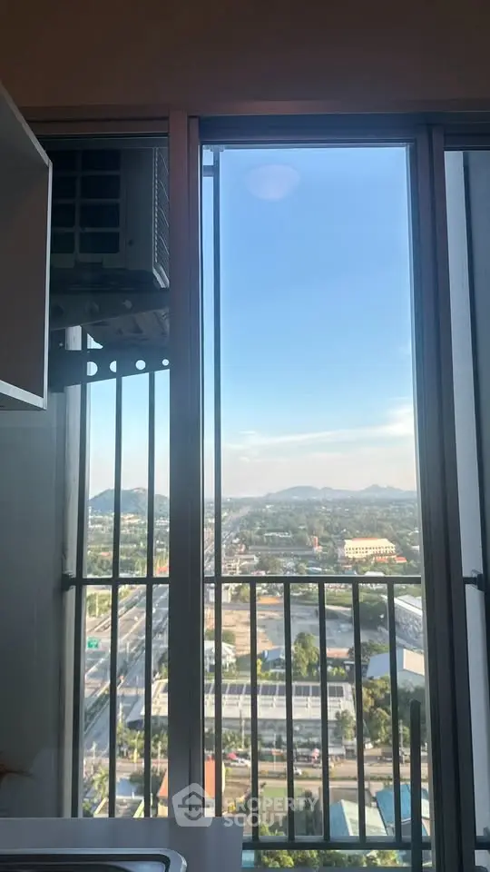 Stunning high-rise apartment view with expansive cityscape and mountains in the background.
