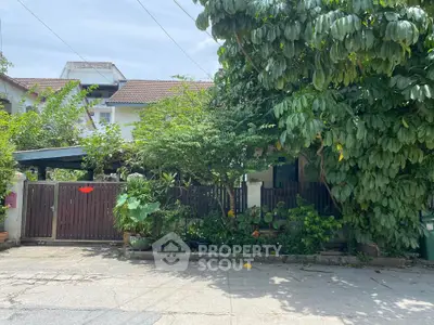 Charming suburban house with lush greenery and wooden gate, perfect for nature lovers seeking tranquility.