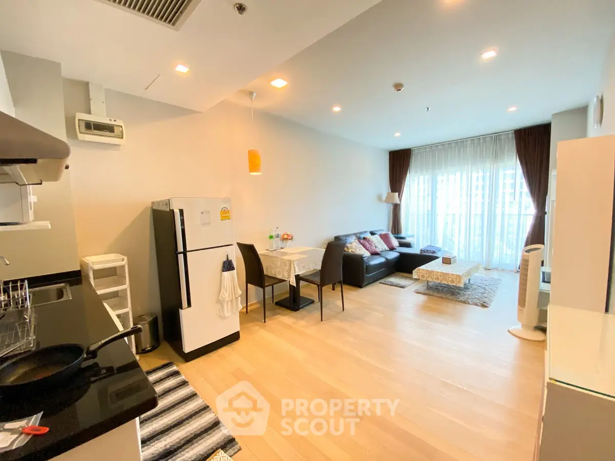 Modern open-layout living room and kitchen with stylish decor and natural light