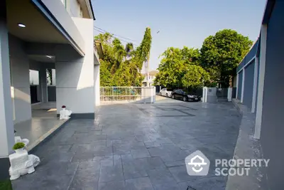 Spacious driveway with modern paving and lush greenery in a contemporary residential property.