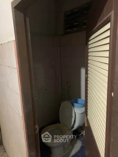 Compact bathroom with basic toilet setup, ideal for small spaces.
