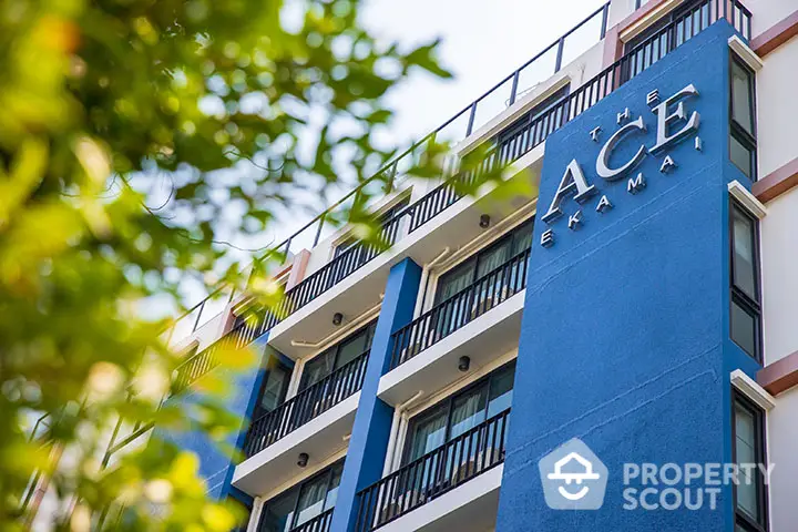 Modern blue apartment building with balconies in urban setting