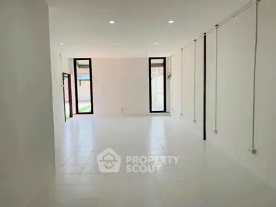 Spacious open-plan interior with large windows and bright lighting, perfect for versatile living or office space.