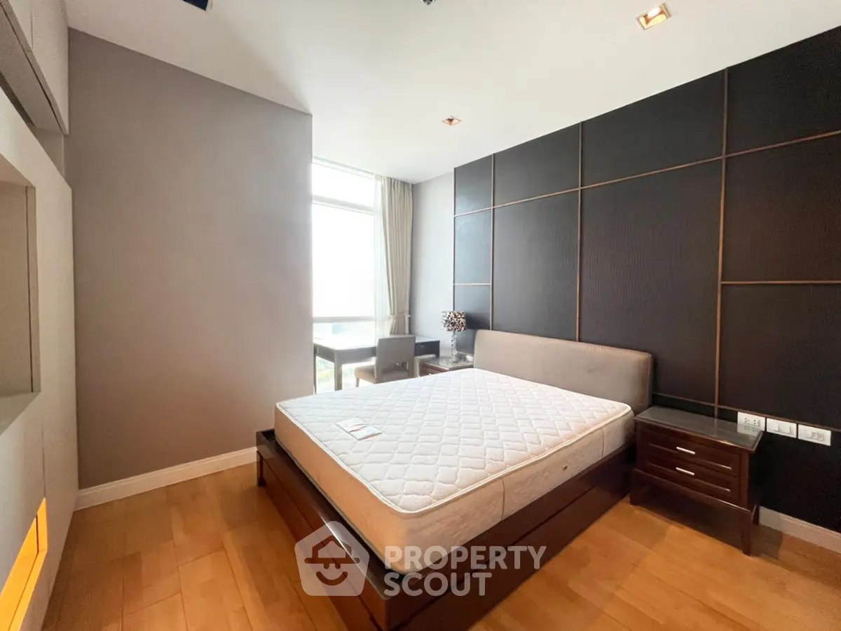 Modern bedroom with large window and stylish decor in a luxury apartment