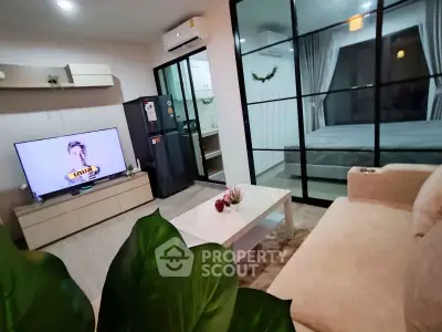 Modern living room with open layout and stylish decor, featuring a cozy sofa and large TV.