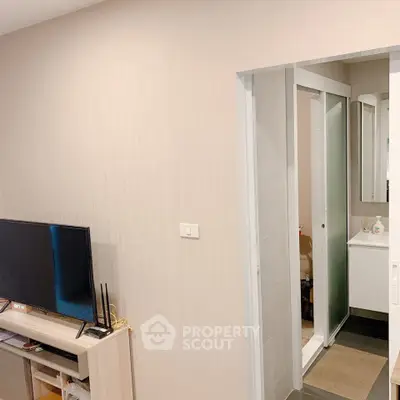 Modern living room with TV and bathroom entrance, ideal for cozy urban living.