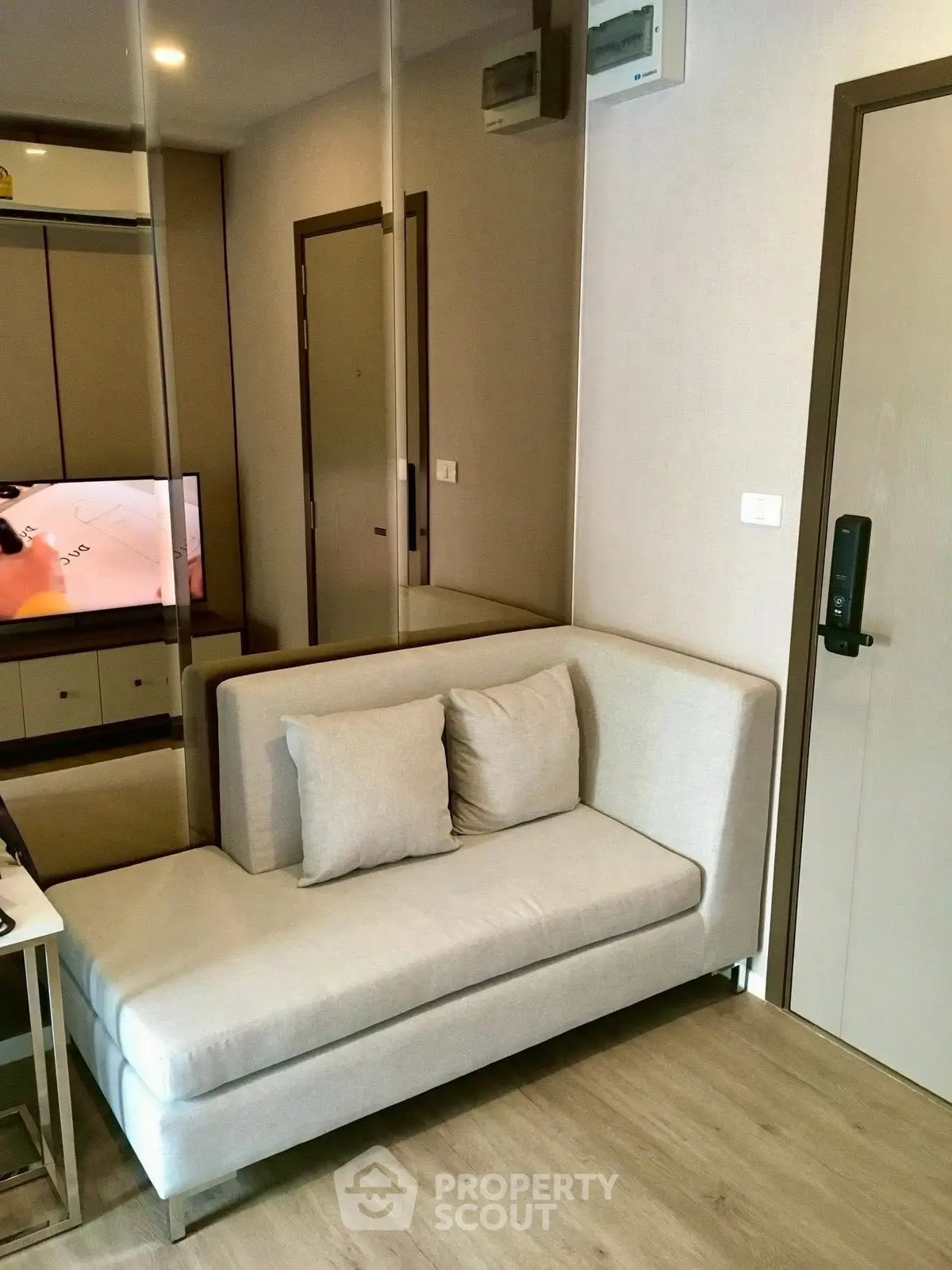 Modern living room with cozy sofa and mirrored wall in stylish apartment