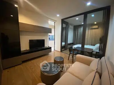 Modern living room with sleek furniture and open view to bedroom, perfect for urban living.