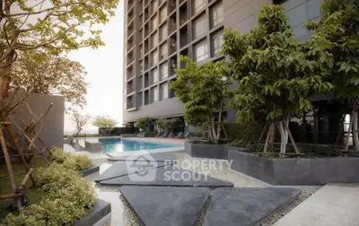 Luxurious modern apartment building with serene pool and lush greenery