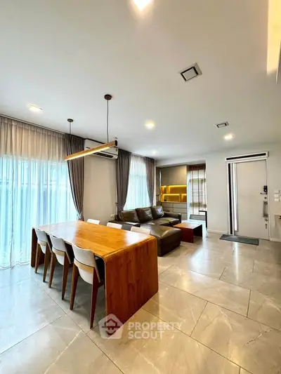 Spacious modern living room with elegant dining area and natural light.