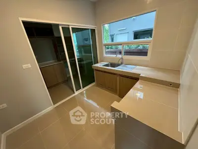 Modern kitchen with sleek cabinetry and large windows for natural light.