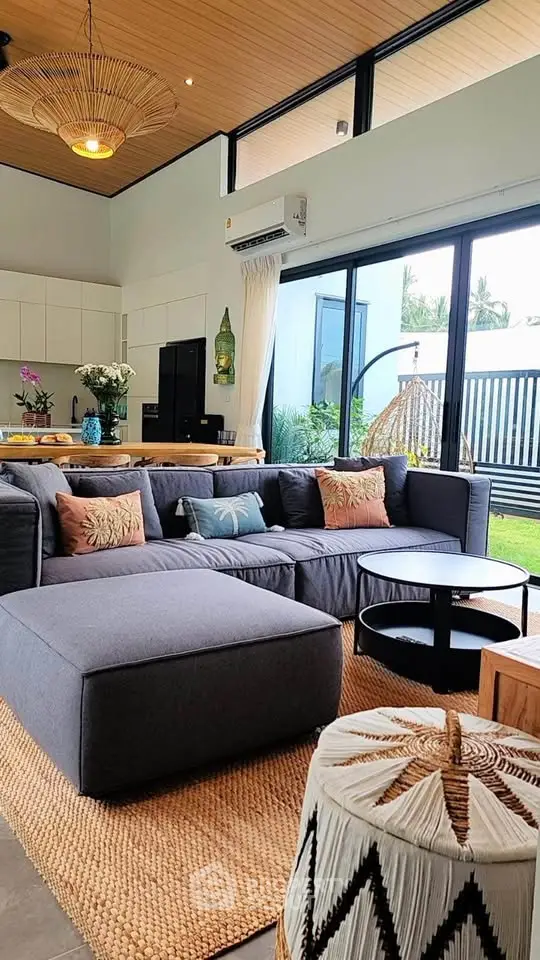 Spacious modern living room with large windows, stylish decor, and garden view, perfect for relaxation.