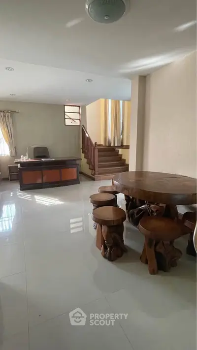 Spacious living area with unique wooden furniture and staircase