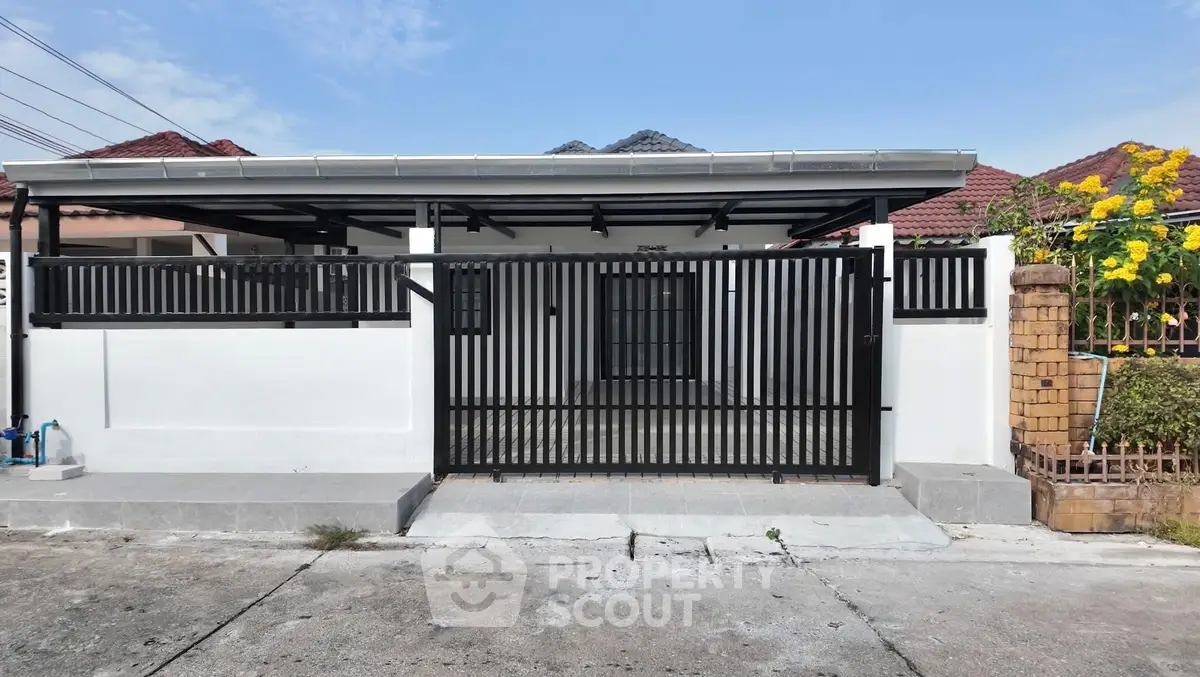 Charming single-story home with modern black gate and spacious driveway