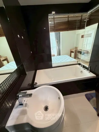 Modern bathroom with sleek black tiles and a spacious bathtub