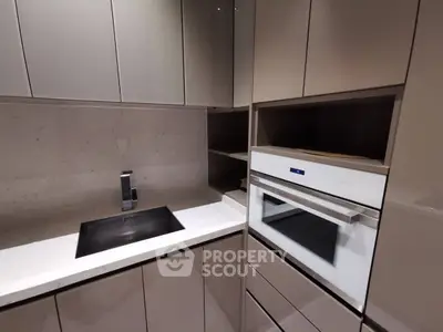 Modern kitchen with sleek cabinetry and built-in oven, perfect for contemporary living.