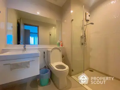 Modern bathroom with glass shower and sleek fixtures in a contemporary home.