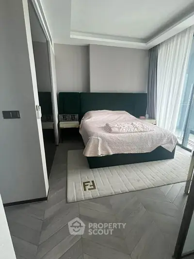 Modern bedroom with stylish decor and large windows offering natural light.