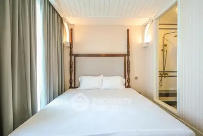 Cozy bedroom with elegant wooden bed frame and large window for natural light.