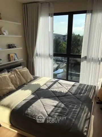 Cozy bedroom with large window and scenic view, featuring modern decor and ample natural light.