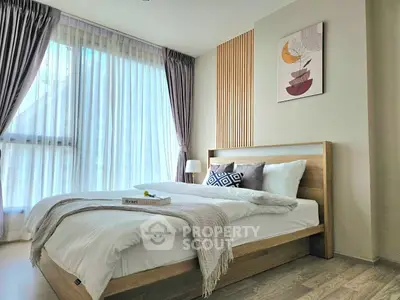 Modern bedroom with natural light, stylish decor, and cozy ambiance.