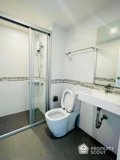 Modern bathroom with glass shower and sleek fixtures in a contemporary apartment.