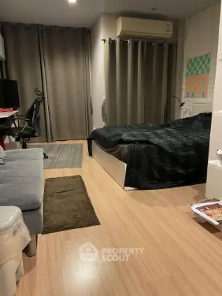 Cozy bedroom with modern decor and wooden flooring, featuring a comfortable bed and stylish workspace.