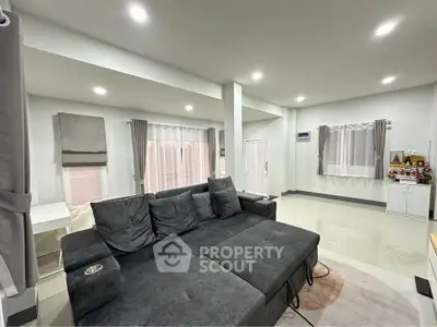 Spacious modern living room with sleek gray sofa and elegant curtains