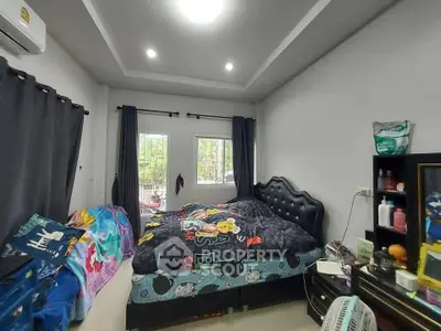 Cozy bedroom with modern decor and ample natural light from large windows.